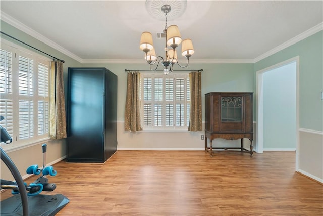 dining area featuring ornamental molding, light hardwood / wood-style flooring, and a notable chandelier