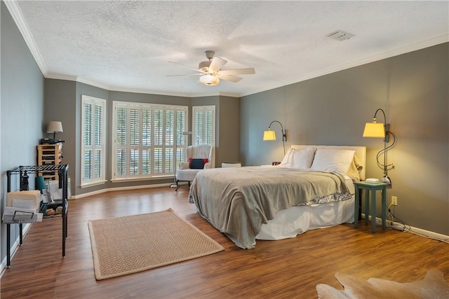 bedroom with hardwood / wood-style flooring, ceiling fan, ornamental molding, and a textured ceiling