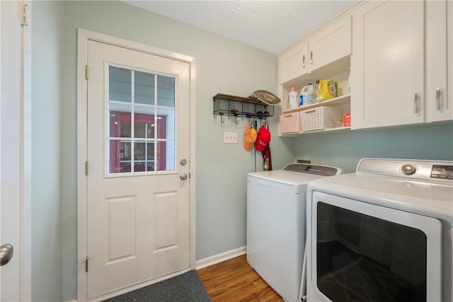 laundry area featuring separate washer and dryer, cabinets, dark hardwood / wood-style floors, and a textured ceiling