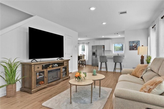 317 Riverwood Village Ln, Sealy, TX 77474 - living room with light wood-type flooring, baseboards, and recessed lighting