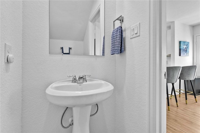 317 Riverwood Village Ln, Sealy, TX 77474 - bathroom featuring a textured wall, wood finished floors, and a sink