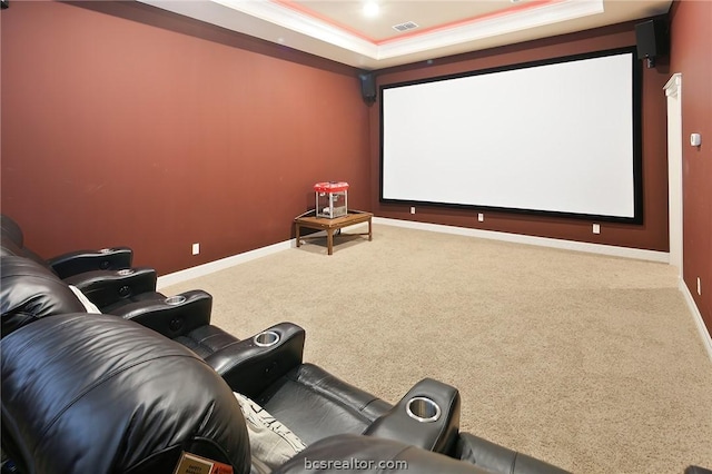 home theater with ornamental molding, carpet floors, and a tray ceiling