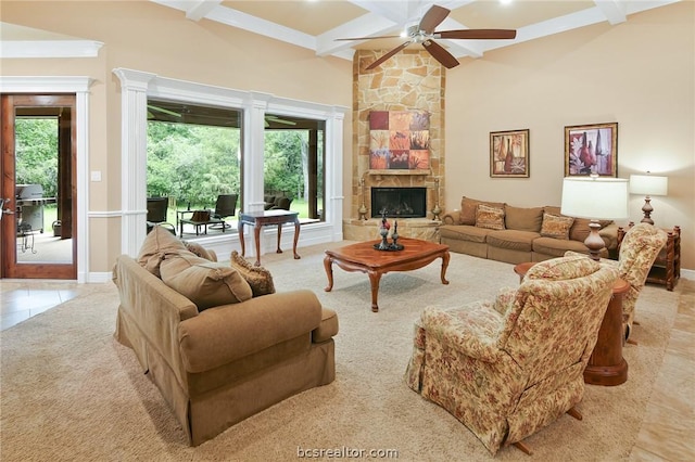 tiled living room with vaulted ceiling with beams, ceiling fan, a stone fireplace, and a wealth of natural light