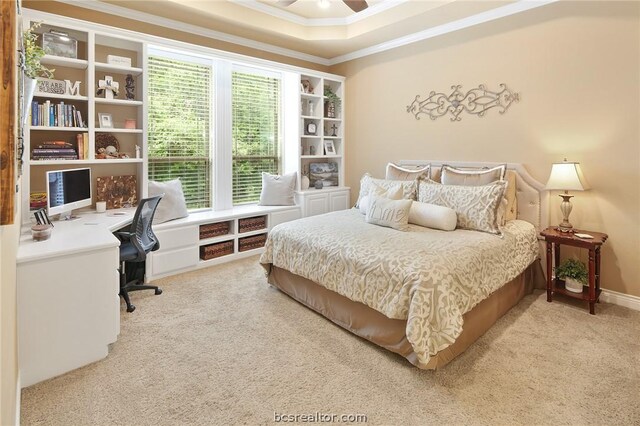 bedroom with a tray ceiling, ceiling fan, crown molding, and carpet floors