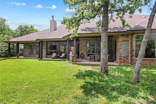 rear view of house with a yard and a patio