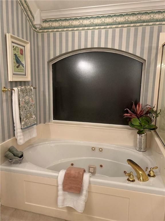 bathroom featuring tile patterned floors and a bath