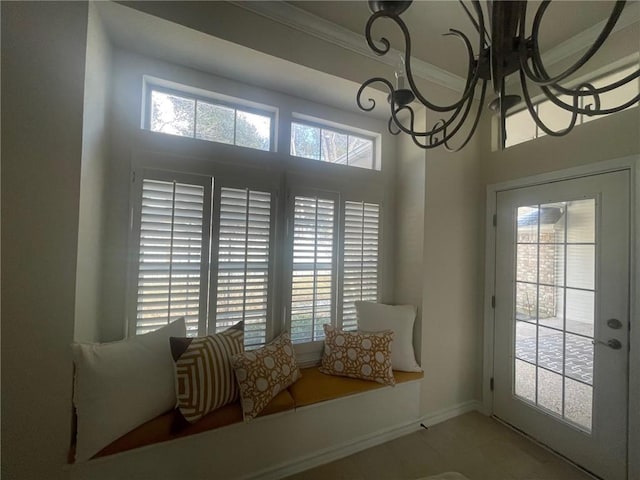 entryway featuring crown molding, a chandelier, and a healthy amount of sunlight