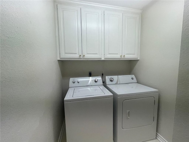 laundry room featuring cabinets and separate washer and dryer