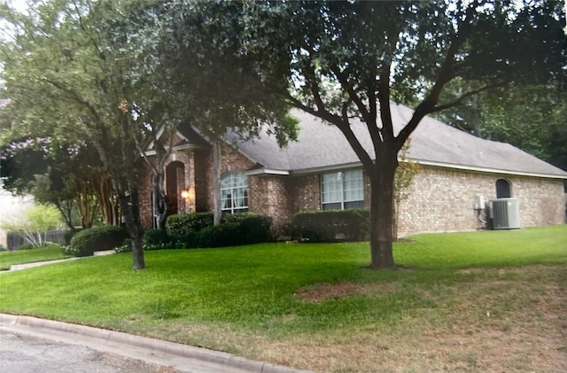 view of front of house with a front yard and central AC