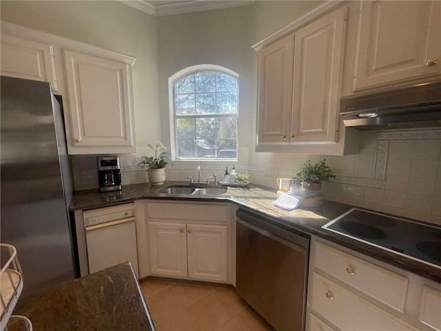 kitchen with white cabinets, appliances with stainless steel finishes, decorative backsplash, sink, and light tile patterned floors