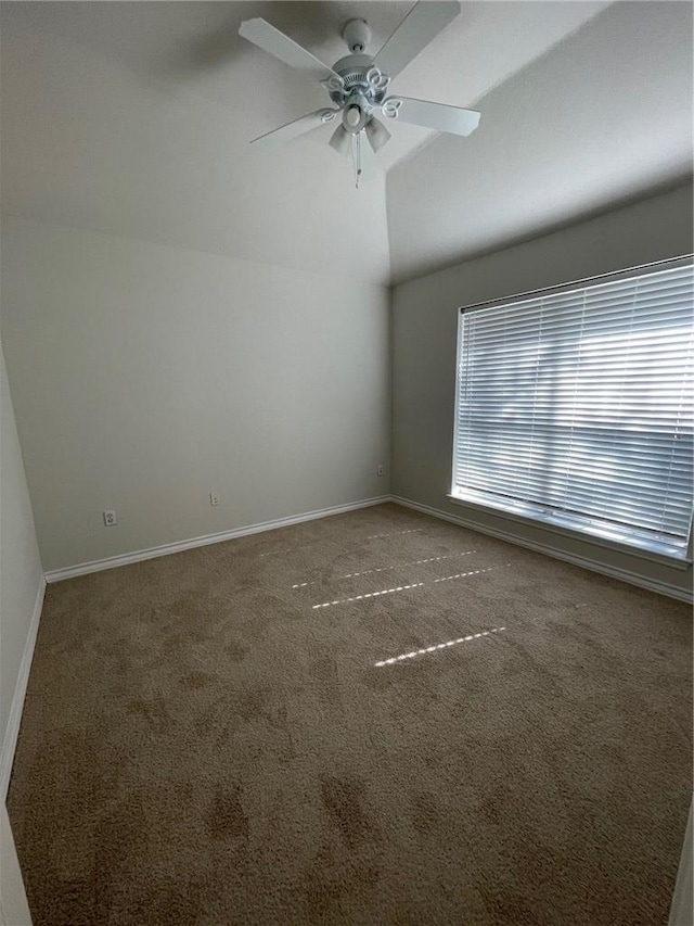 carpeted spare room with ceiling fan and vaulted ceiling