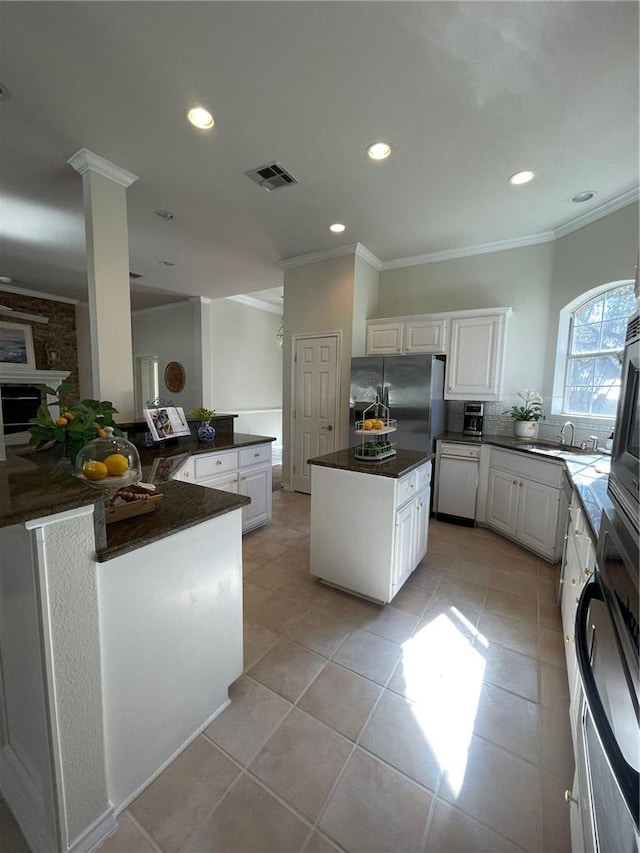 kitchen with dishwasher, a center island, white cabinetry, sink, and light tile patterned floors