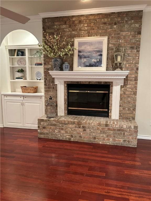 interior details featuring wood-type flooring, a brick fireplace, and crown molding