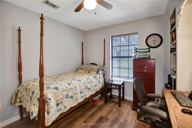 bedroom featuring a textured ceiling, ceiling fan, and dark wood-type flooring