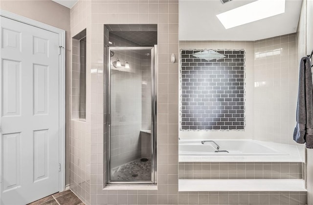 bathroom featuring separate shower and tub and a skylight