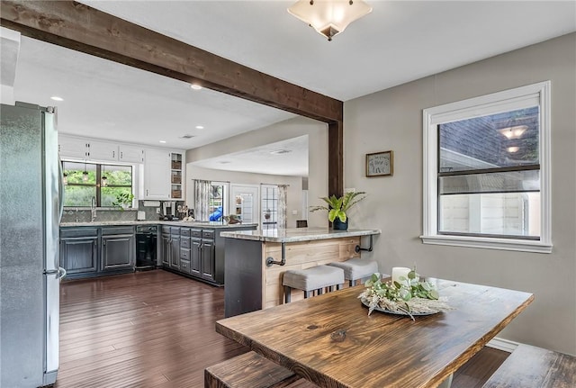 dining area with beam ceiling, sink, beverage cooler, and dark wood-type flooring