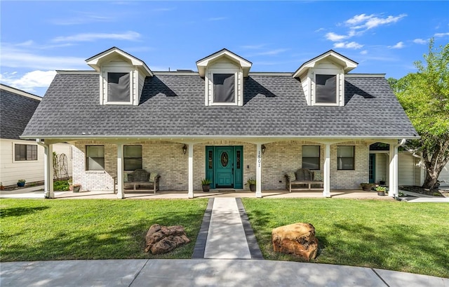 cape cod house with covered porch and a front yard