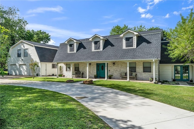 new england style home featuring a porch, a garage, and a front lawn