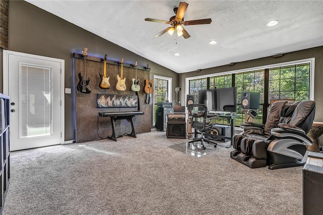 carpeted office space featuring a textured ceiling, vaulted ceiling, plenty of natural light, and ceiling fan