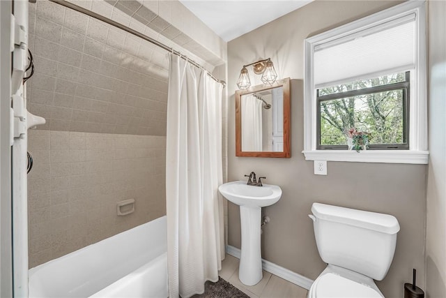 bathroom with tile patterned floors, shower / bath combination with curtain, and toilet