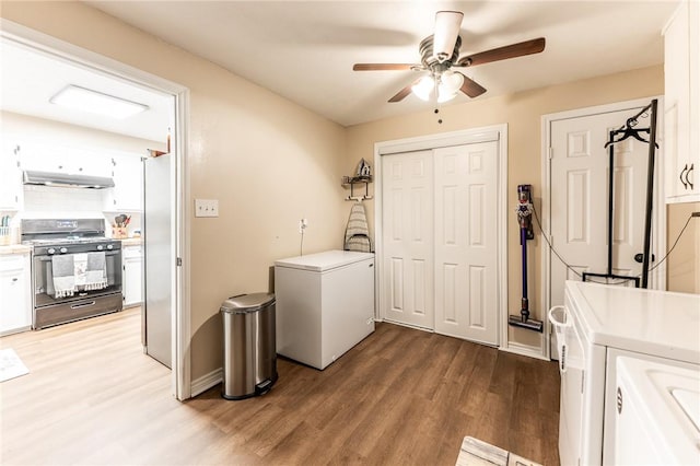 laundry area featuring ceiling fan, wood-type flooring, and separate washer and dryer