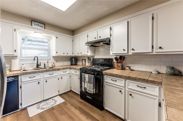 kitchen with white cabinetry, light hardwood / wood-style flooring, and black appliances