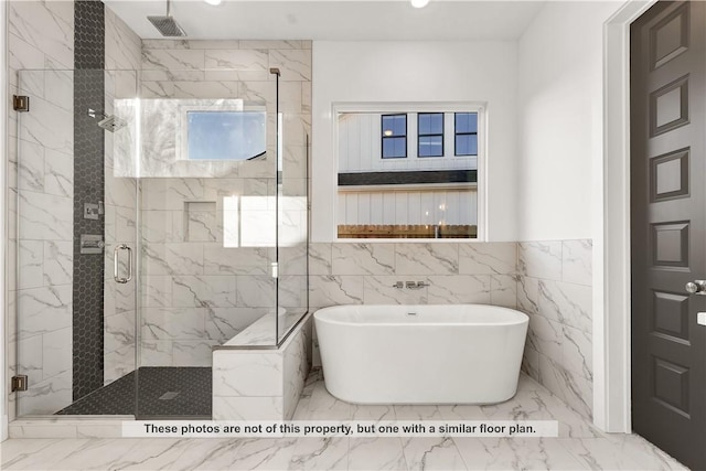 bathroom featuring tile walls and independent shower and bath