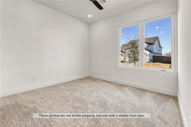 carpeted spare room featuring ceiling fan