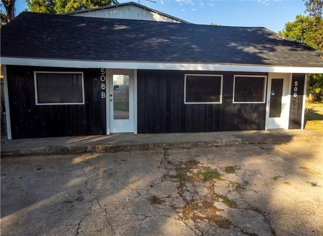 exterior space featuring roof with shingles