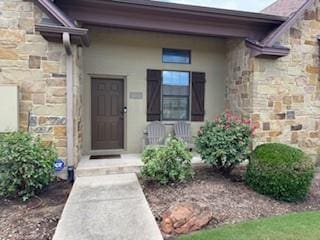3349 General Pkwy, College Station, TX 77845 - doorway to property with stone siding, stucco siding, and a porch