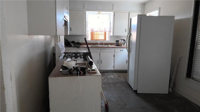 kitchen with sink, white fridge, and white cabinets