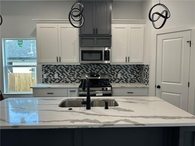 705 Waco St, Bryan, TX 77803 - kitchen featuring appliances with stainless steel finishes, backsplash, decorative light fixtures, and light stone counters