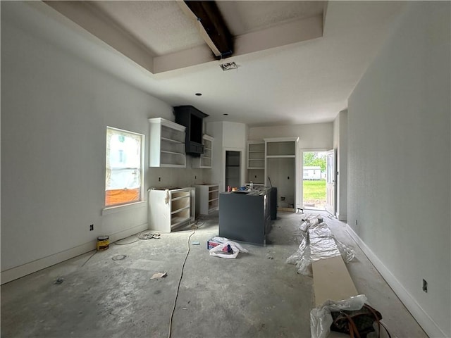 kitchen featuring open shelves, beam ceiling, and a center island