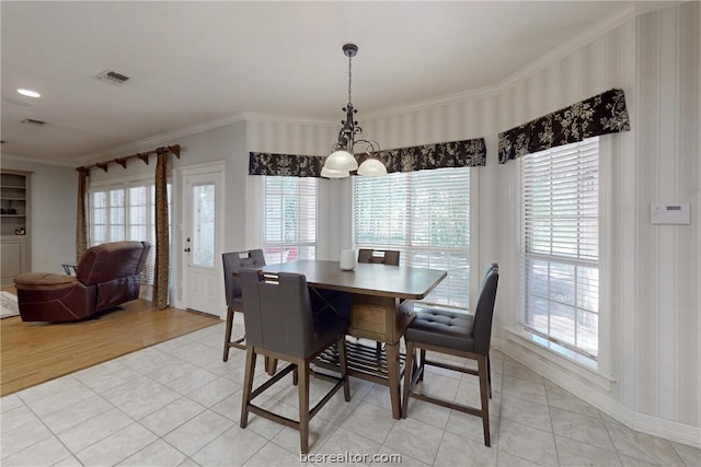 dining area featuring a wealth of natural light, light hardwood / wood-style flooring, an inviting chandelier, and ornamental molding