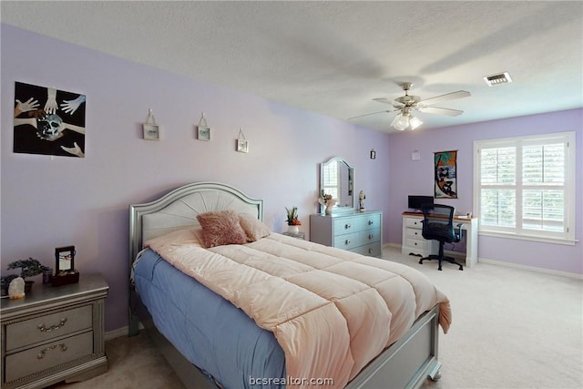 carpeted bedroom featuring a textured ceiling and ceiling fan