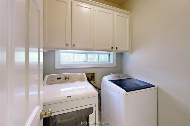 washroom featuring cabinets and washing machine and dryer