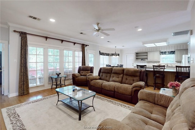 living room with ceiling fan, light hardwood / wood-style flooring, and ornamental molding