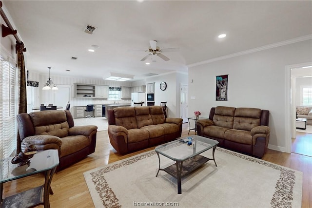 living room with crown molding, ceiling fan, and light hardwood / wood-style floors