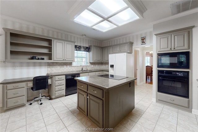 kitchen with a center island, sink, tasteful backsplash, black appliances, and ornamental molding