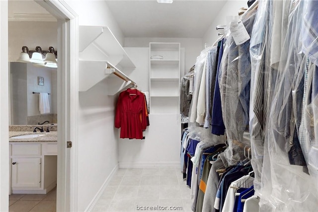 spacious closet featuring light tile patterned floors and sink