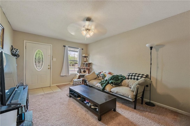 living room featuring a textured ceiling, ceiling fan, and light carpet