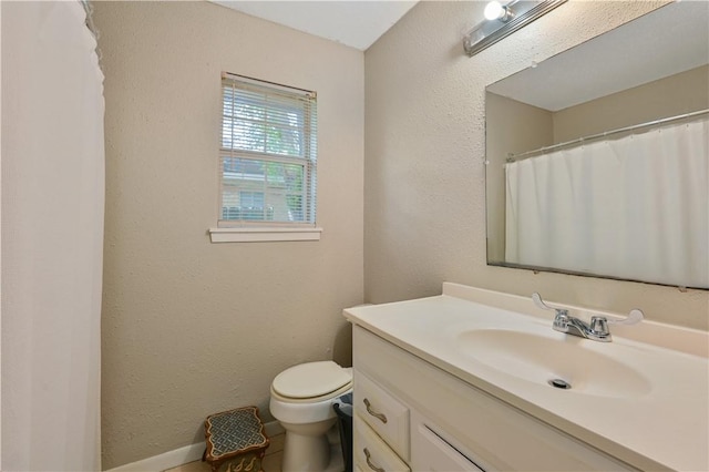 bathroom with vanity, toilet, and baseboards