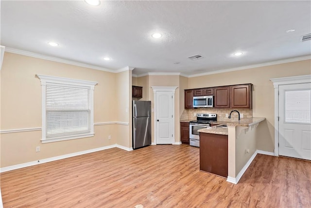 kitchen featuring stainless steel appliances, light hardwood / wood-style floors, crown molding, and sink