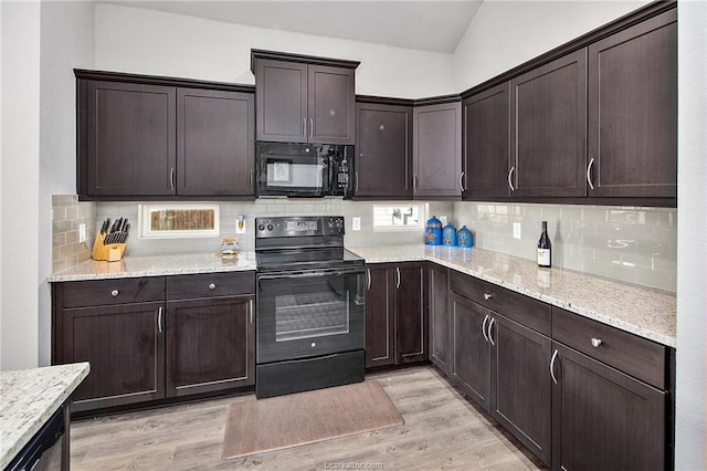 kitchen with backsplash, black appliances, vaulted ceiling, and light wood-type flooring