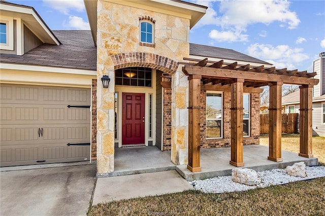 2025 Jester Trl, Bryan, TX 77807 - view of exterior entry with a garage, stone siding, brick siding, and roof with shingles