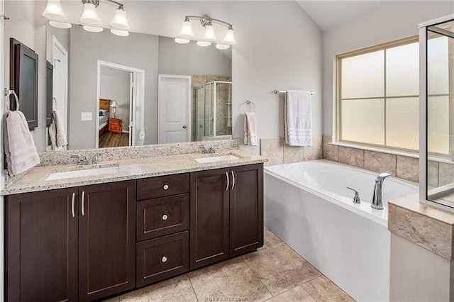 bathroom featuring tile patterned floors, vanity, vaulted ceiling, and shower with separate bathtub