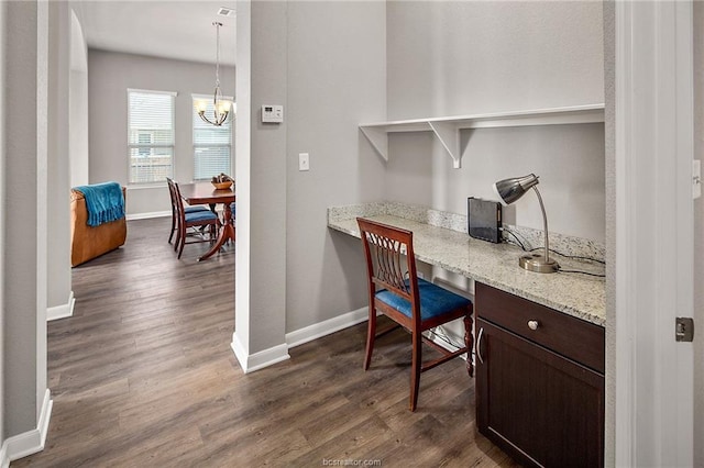 office space featuring dark wood-type flooring and a notable chandelier