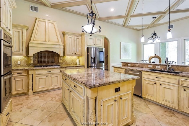 kitchen featuring decorative light fixtures, a center island, sink, and stainless steel appliances