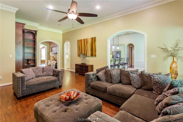 living room with dark hardwood / wood-style flooring, ceiling fan, and crown molding