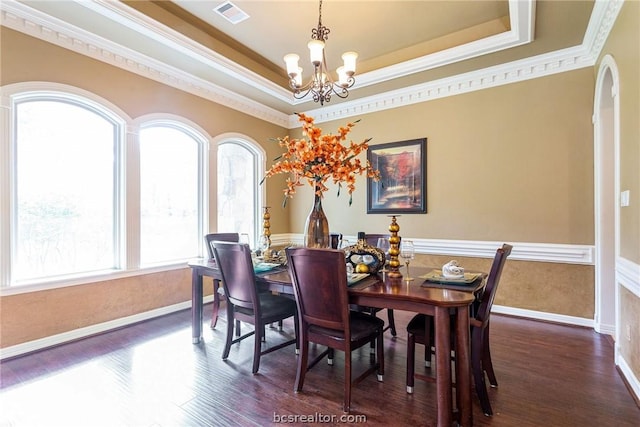 dining area with dark wood-type flooring, plenty of natural light, and a chandelier